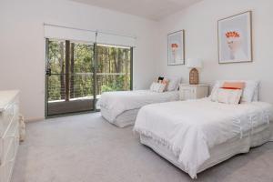 um quarto branco com duas camas e uma janela em Karingal just minutes from Blueys Beach em Charlotte Bay