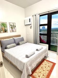 ein Schlafzimmer mit einem großen Bett mit einem großen Fenster in der Unterkunft Peaceful Panglao Escape for Families & Couples in Dao