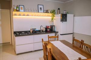 een keuken met een tafel, een fornuis en een koelkast bij Apartamento 1 Quarto Canasvieiras in Florianópolis +8 foto's
