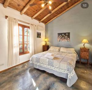 ein Schlafzimmer mit einem Bett und einer Decke in der Unterkunft Posada La Lucía in Villa General Belgrano