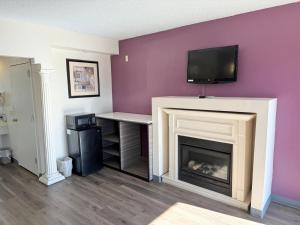 a living room with a fireplace with a tv above it at Express Inn-Rahway in Rahway