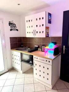 a kitchen with white cabinets and a counter top at Cinéma Room - La Valette - Toulon - Hyères in La Valette-du-Var