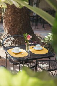 ein Tisch mit zwei Tassen und einer Vase mit Blumen darauf in der Unterkunft Hotel Allende Morelia in Morelia