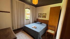 a bedroom with a blue bed and a window at Sítio Chamego - RJ in Engenheiro Paulo de Frontin +61 photos