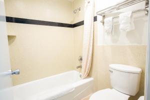 a bathroom with a white toilet and a shower at Tropic Lodge in Anaheim