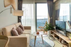 a living room with a couch and a large window at CĂN HỘ THE SÓNG TAM THẮNG VŨNG TÀU - LUXURY APARTMENT Mr Tú in Vung Tau +133 photos