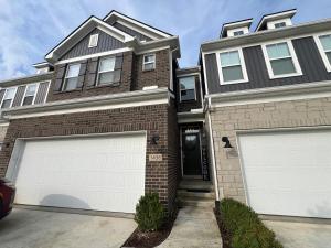 une maison avec deux portes de garage devant elle dans l'établissement Kensington Kickback QUICK Access to Ann Arbor, 