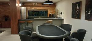 a room with a bar with chairs and a table at Studio Luxuoso vista Mar in Salvador