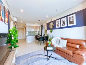 un salon avec un canapé marron et une cuisine dans l'établissement CĂN HỘ THE SÓNG TAM THẮNG VŨNG TÀU - LUXURY APARTMENT Mr Tú, à Vung Tau