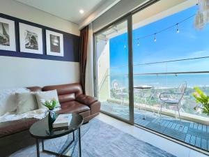 头顿CĂN HỘ THE SÓNG TAM THẮNG VŨNG TÀU - LUXURY APARTMENT Mr Tú的带沙发和大窗户的客厅
