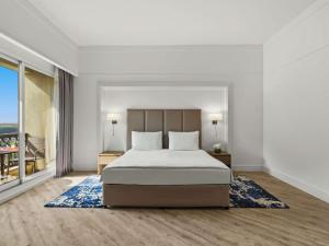 a bedroom with a bed and a large window at Rixos Bab Al Bahr - Ultra All Inclusive in Ras al Khaimah