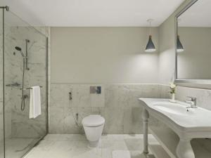 a bathroom with a toilet and a sink and a shower at Rixos Bab Al Bahr - Ultra All Inclusive in Ras al Khaimah