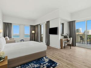 a hotel room with a bed and a television at Rixos Bab Al Bahr - Ultra All Inclusive in Ras al Khaimah