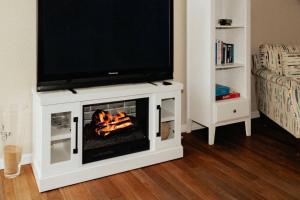 une cheminée avec une télévision au-dessus dans l'établissement Waterfront condo -shop-beach-bike-boat-pool-chill, à Saugatuck