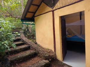 ein Gebäude mit einer Tür mit einem Bett darin in der Unterkunft Busuanga Backpackers in Busuanga + 1 Foto