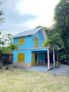 una casa blu con porte gialle e palme di Retiro Esperança a Santa Isabel do Pará