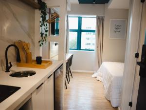 uma cozinha com uma pia e uma cama em um quarto em Apê Itaim Bibi - Soft Opening em São Paulo
