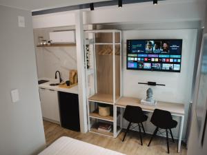 um quarto com duas cadeiras e uma televisão na parede em Apê Itaim Bibi - Soft Opening em São Paulo mais 12 fotografias