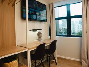um quarto com uma secretária com 2 cadeiras e uma janela em Apê Itaim Bibi - Soft Opening em São Paulo
