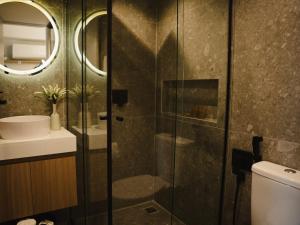 um banheiro com chuveiro, vaso sanitário e pia em Apê Itaim Bibi - Soft Opening em São Paulo