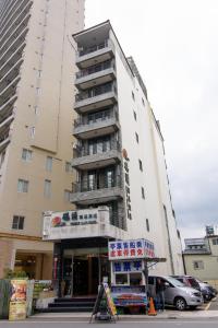 a tall building with a sign in front of it at Harbor Elite Hotel in Yuchi