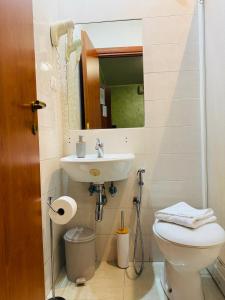 ein Badezimmer mit Toilette, Waschbecken und Spiegel in der Unterkunft Dreamland Guesthouse in Rom