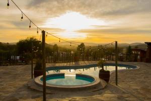 une piscine avec un coucher de soleil en arrière-plan dans l'établissement Villa De La Rosa at Valle de Gpe Pool BBQ & AC, à San Pablo