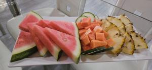 a plate with slices of watermelon and other fruits at CROOКED TREE LODGE Belize in Crooked Tree