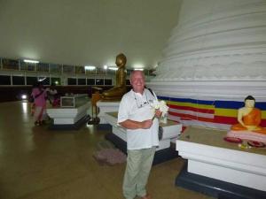 un hombre parado frente a una gran estatua en Indivilla, en Kalutara