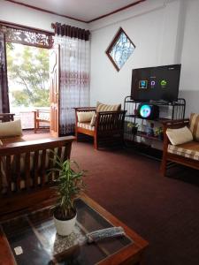 a living room with a tv and a couch at Penthouse Bandarawela in Bandarawela