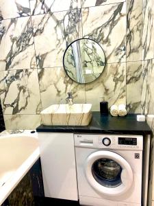 a bathroom with a sink and a washing machine at Транзит Сервис 1 Аэропорт- Кишинёв in Chişinău