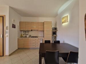 a kitchen with a table and chairs and a table and a kitchen at T2 Djadsal Bloco Laranja Perto da Praia e Centro in Santa Maria