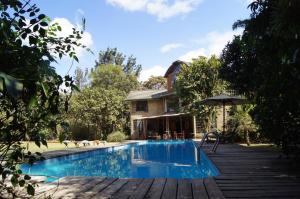 a swimming pool in front of a house at Meru House Lekisilai in Arusha