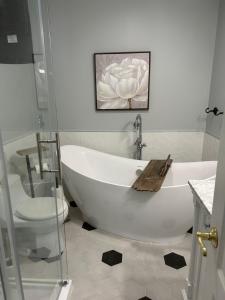 a bathroom with a white tub and a toilet at Tait Lake Retreat - Luxury Lakeside Home in Turriff +142 photos