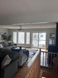 a living room with a couch and some windows at Tait Lake Retreat - Luxury Lakeside Home in Turriff