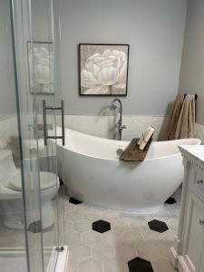 a white bathroom with a tub and a toilet at Tait Lake Retreat - Luxury Lakeside Home in Turriff
