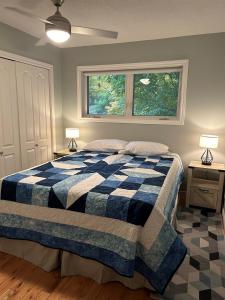 a bedroom with a blue and white bed with two lamps at Tait Lake Retreat - Luxury Lakeside Home in Turriff