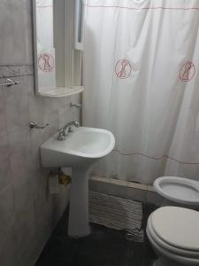 un bagno con lavandino, WC e tenda da doccia di Chalet en Mogotes a Mar del Plata