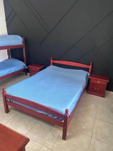 una camera da letto con un letto con lenzuola blu e due tavoli di Chalet en Mogotes a Mar del Plata