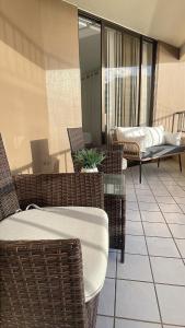 un balcón con sillas de mimbre y una mesa en un edificio en New Ocean View Condominium, en Honolulu