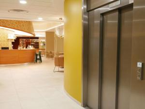 a hallway with a yellow wall in a office at Mercure Vichy in Vichy