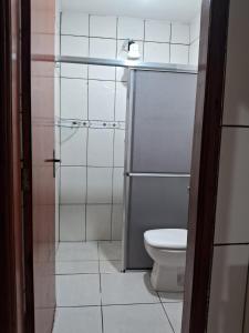 ein Badezimmer mit Toilette und Glasdusche in der Unterkunft Casa da Porteira in Caldas Novas + 3 Fotos