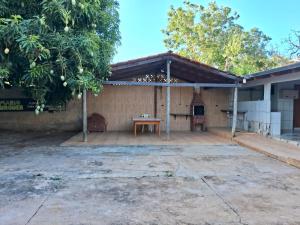 eine Außenterrasse mit einem Tisch und einem Baum in der Unterkunft Casa da Porteira in Caldas Novas