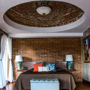 une chambre avec un lit et un mur de briques dans l'établissement Suite Mediterranea Valle de Gpe WiFi BBQ & Pool, à Villa de Juárez
