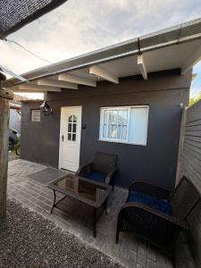 eine Terrasse mit zwei Korbstühlen und einem Tisch in der Unterkunft Cocheras Ezeiza Victoria in Ezeiza