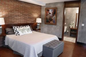 une chambre avec un grand lit et un mur de briques dans l'établissement Suite Mediterranea Valle de Gpe WiFi BBQ & Pool, à Villa de Juárez 63 autres photos