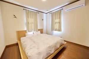 une chambre avec un lit avec des draps blancs et une fenêtre dans l'établissement Atami Regalo - Vacation STAY 62917v, à Atami
