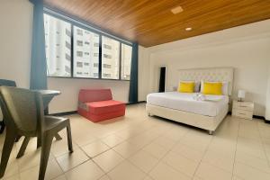 a bedroom with a bed and a desk and a chair at Las casas de tomate Cartagena in Cartagena de Indias