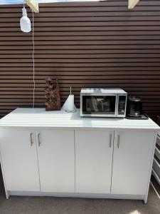 Un mostrador blanco con un microondas encima. en Montrose holiday cottage, en Rosetta