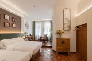 a hotel room with two beds and a table at TeaHouse Hotel in Xiamen
